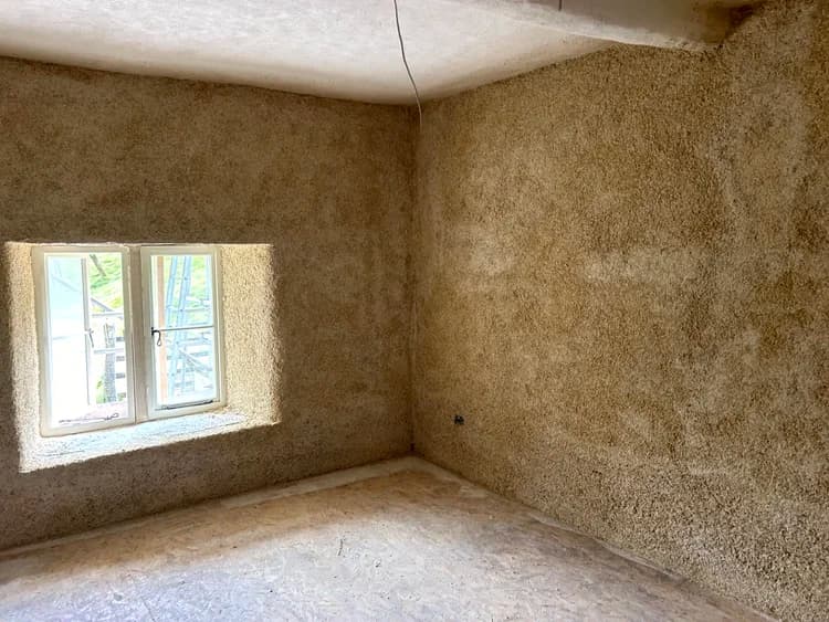 Sprayed hempcrete interior corner showing even coverage to walls and window reveal