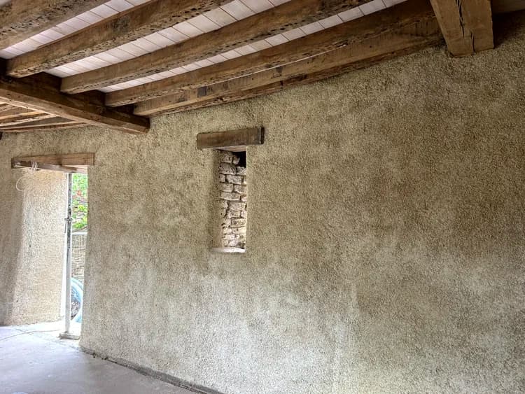 Sprayed hempcrete to walls and exposed timber beams in a stone barn interior
