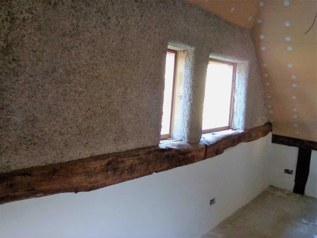 Interior gable showing hempcrete and oak frame, partly plastered