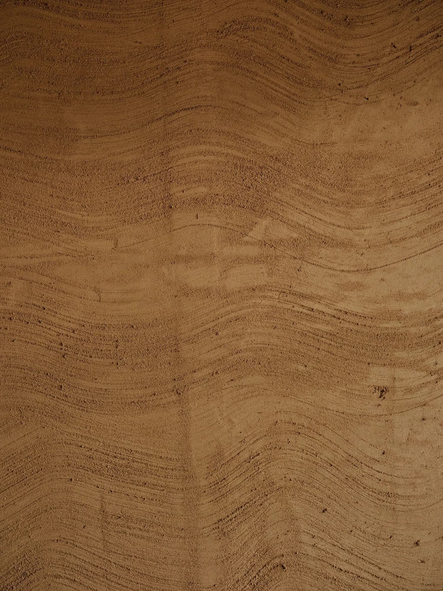 Hand-applied clay plaster detail showing natural texture